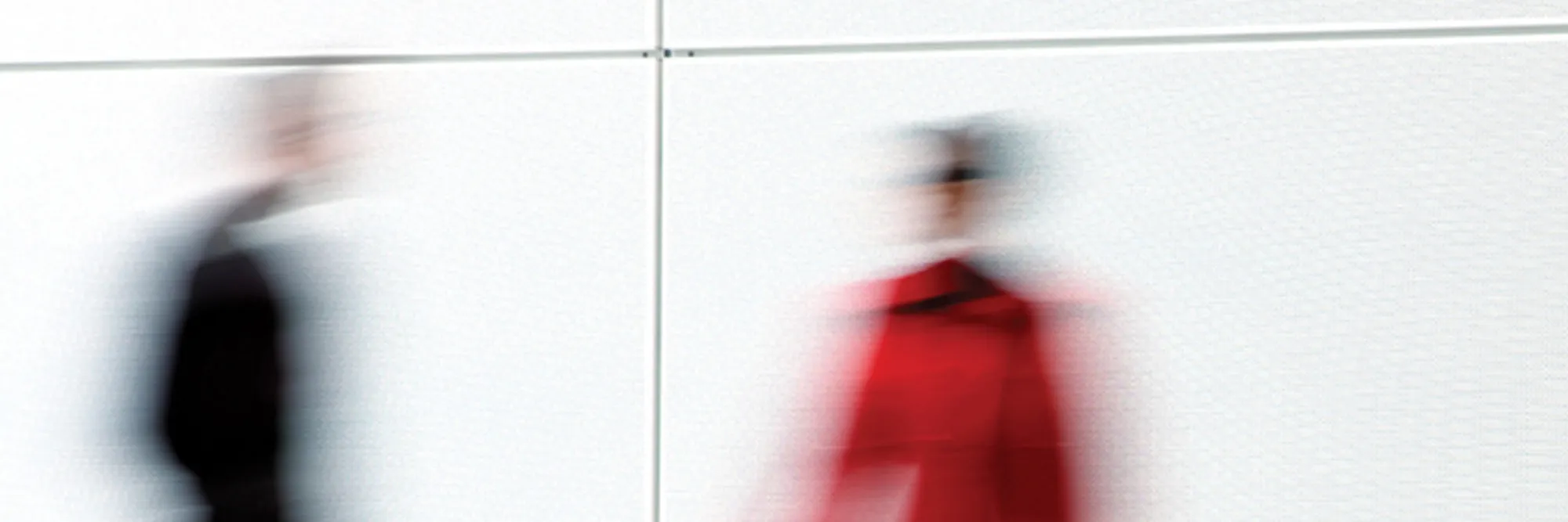 People moving through a busy workplace, motion-blurred