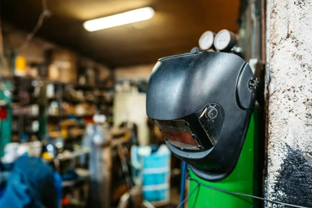 Welding helmet hanging in a busy workshop