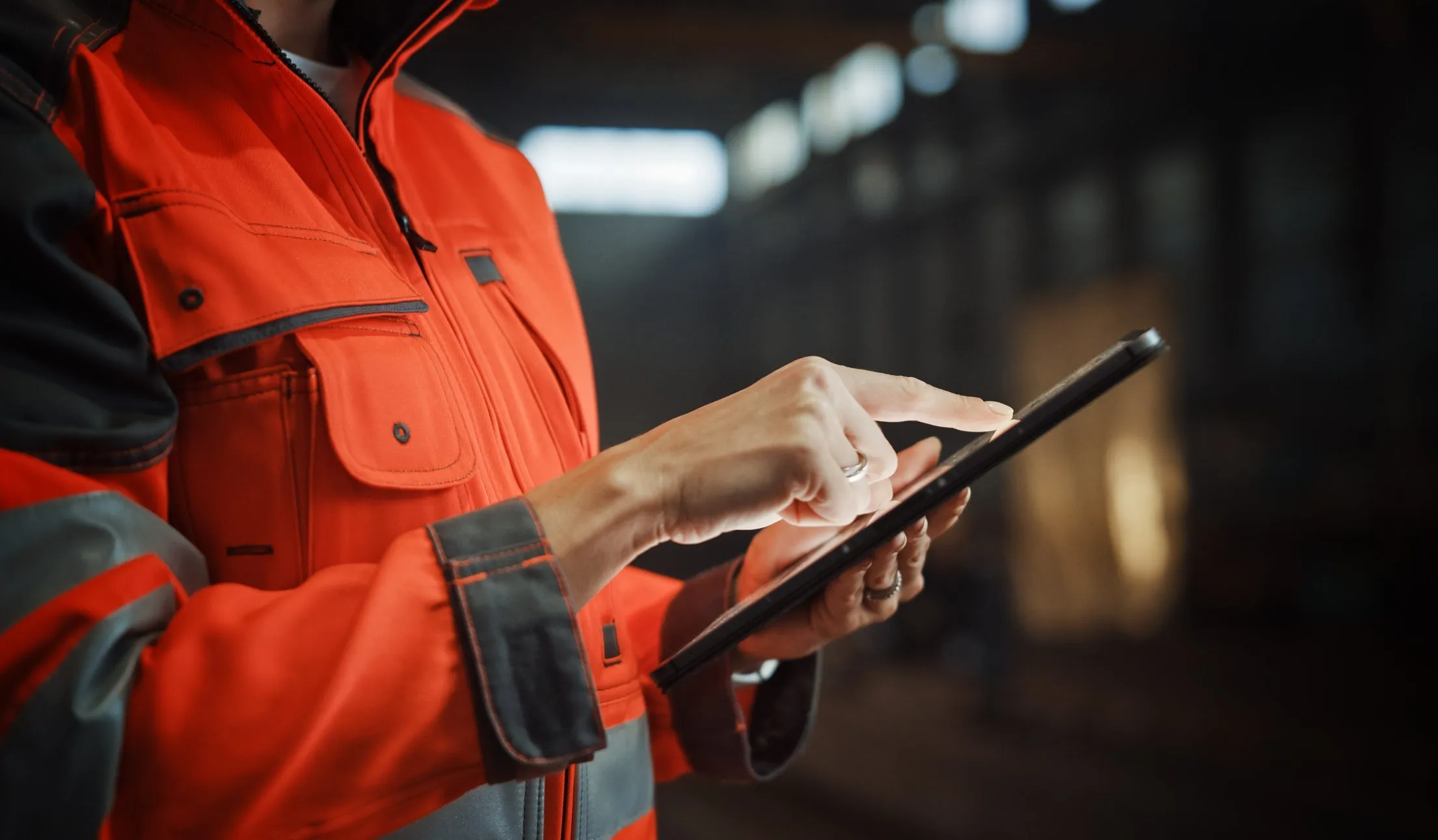 Worker in high-visibility gear using a tablet