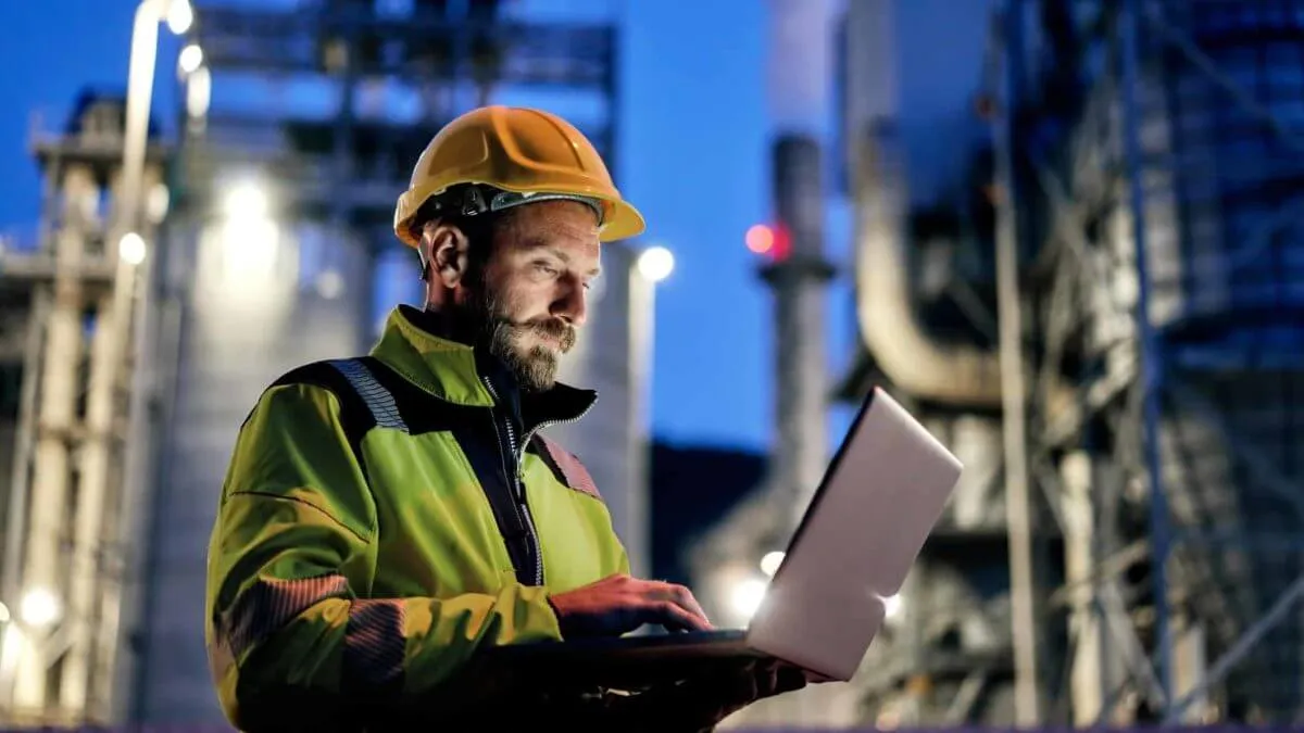 Engineer in a hard hat working on a laptop