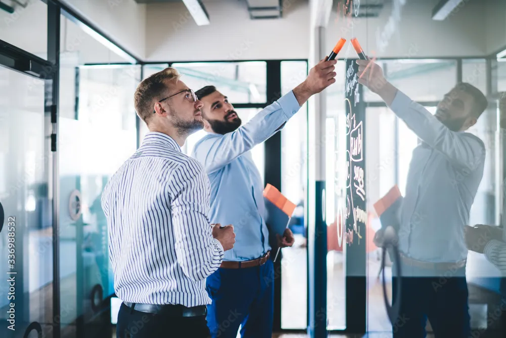 Colleagues planning together at a glass wall
